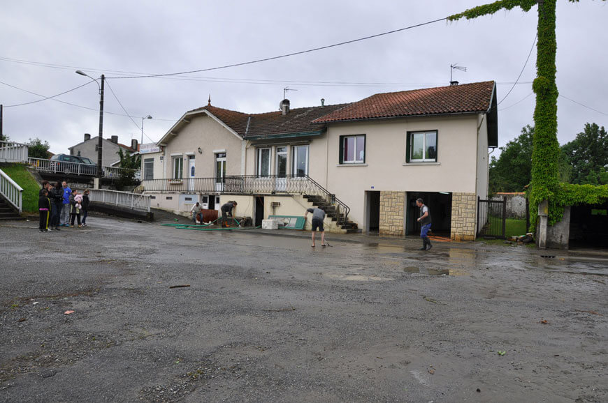 Habitants qui nettoient leur quartier après le passage des eaux en 2013