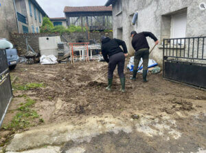 Des hommes déblaient la terre après la crue à Ardiège